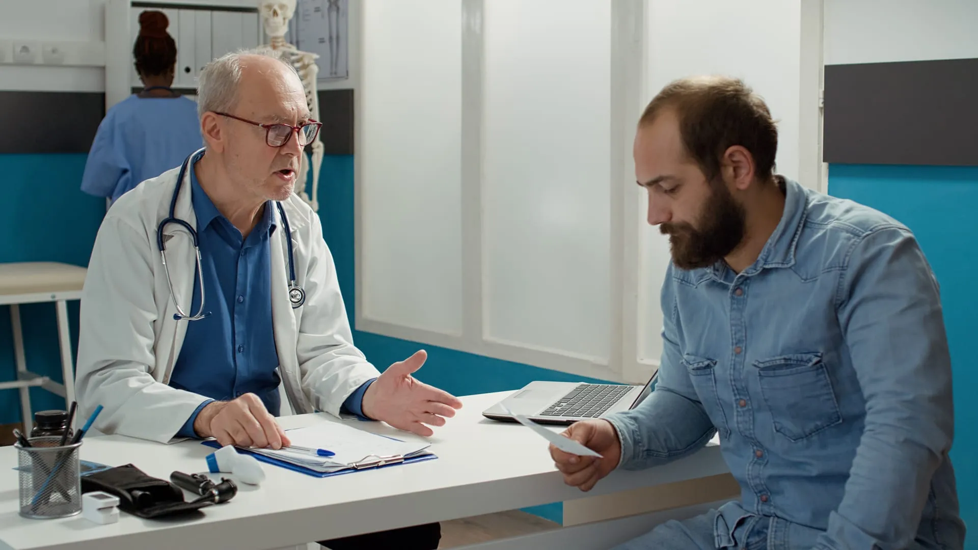 Arzt bespricht mit einem Patienten die Unterlagen