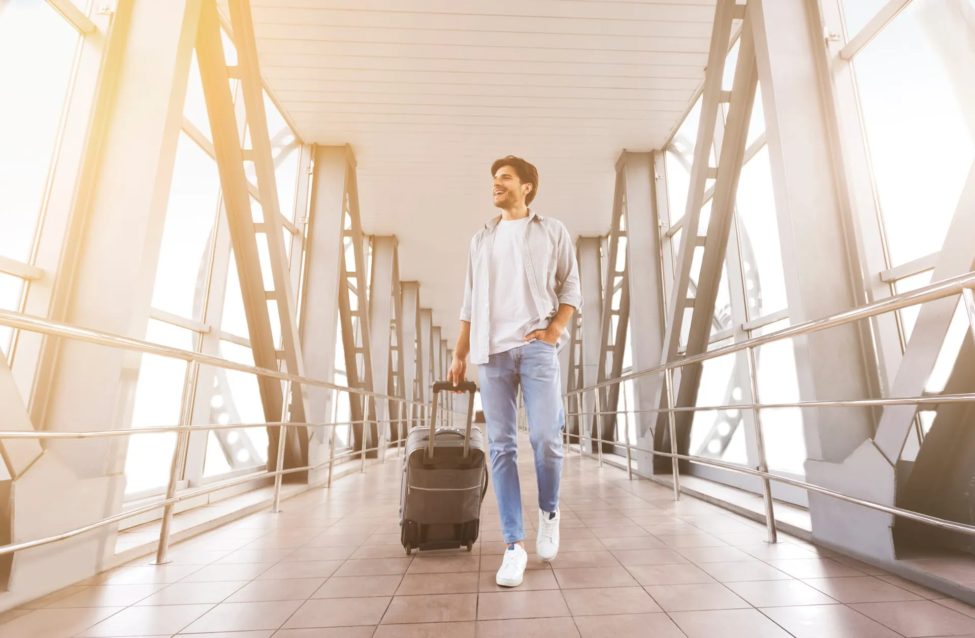 Mann mit Rollkoffer am Flughafen