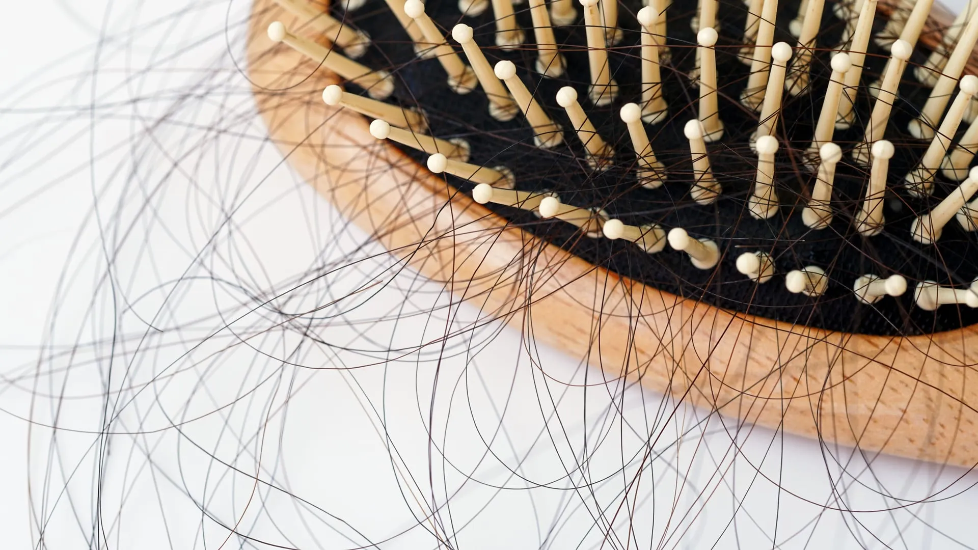 Ausgefallene Haare neben einer Haarbürste
